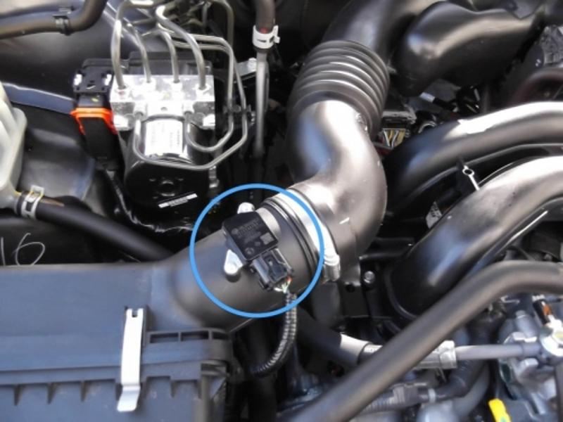 Kỹ thuật viên kiểm tra mạch điện van IACV ô tô bằng đồng hồ vạn năng để phát hiện lỗi
