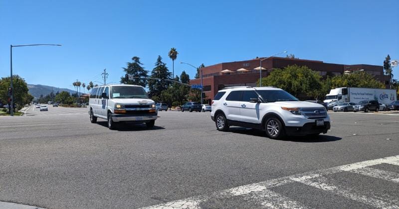 Một chiếc ô tô đang di chuyển trong thành phố đông đúc với các tòa nhà cao tầng