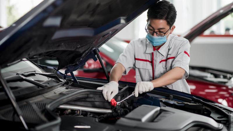 Hình ảnh minh họa động cơ ô tô với các bobin đánh lửa được đánh dấu, cho thấy vị trí và một bobin có dấu hiệu hư hỏng như nứt, chảy dầu, minh họa dấu hiệu bobin đánh lửa bị hư gây ảnh hưởng đến hoạt động của xe ô tô.